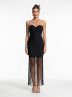 Black strapless gown with sheer fringe details on a white background