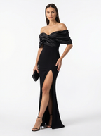 Woman wearing a black off-shoulder gown with a high slit on a white background