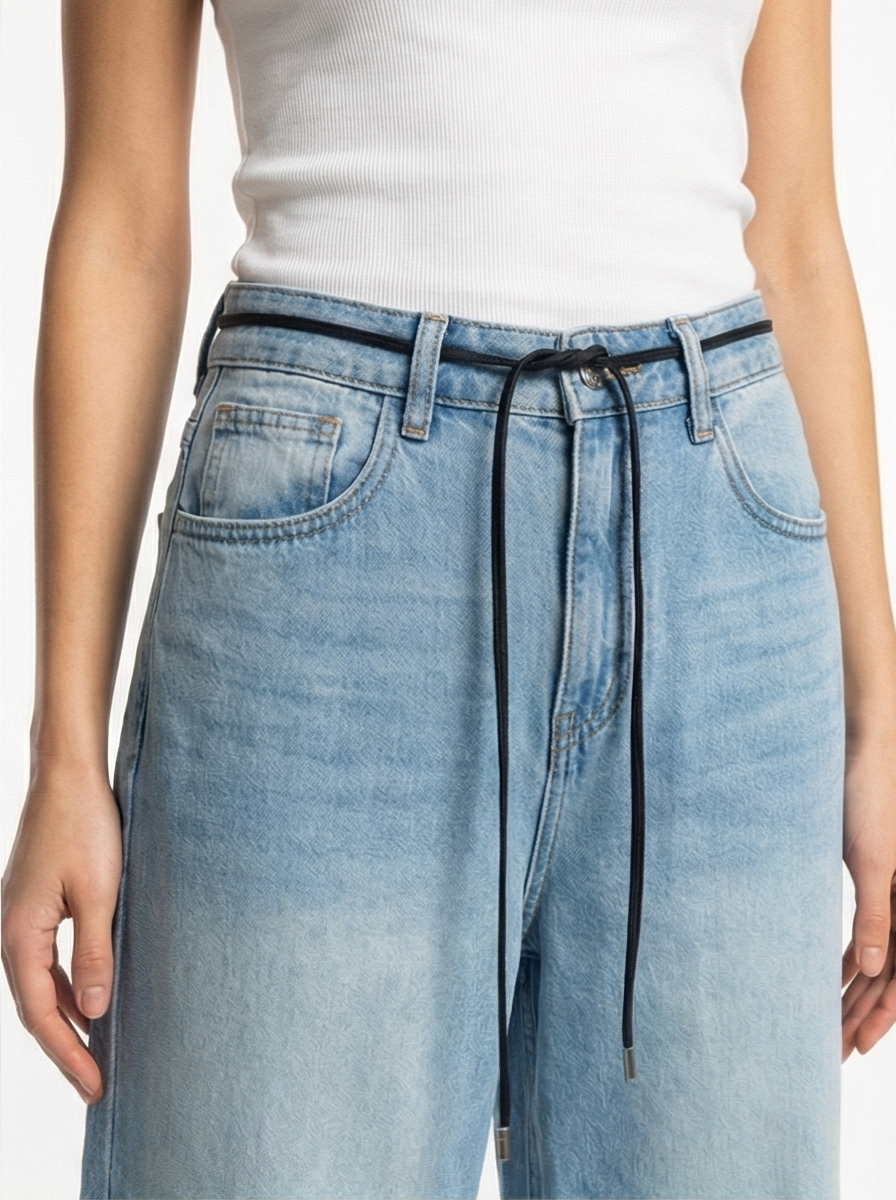 Light blue denim pants with a white top on a plain background