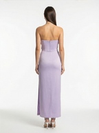 Woman wearing a strapless lavender gown on a white background