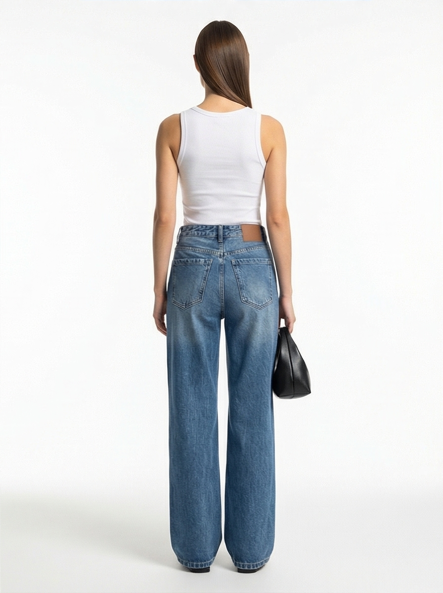 Woman wearing blue jeans and a white top on a white background