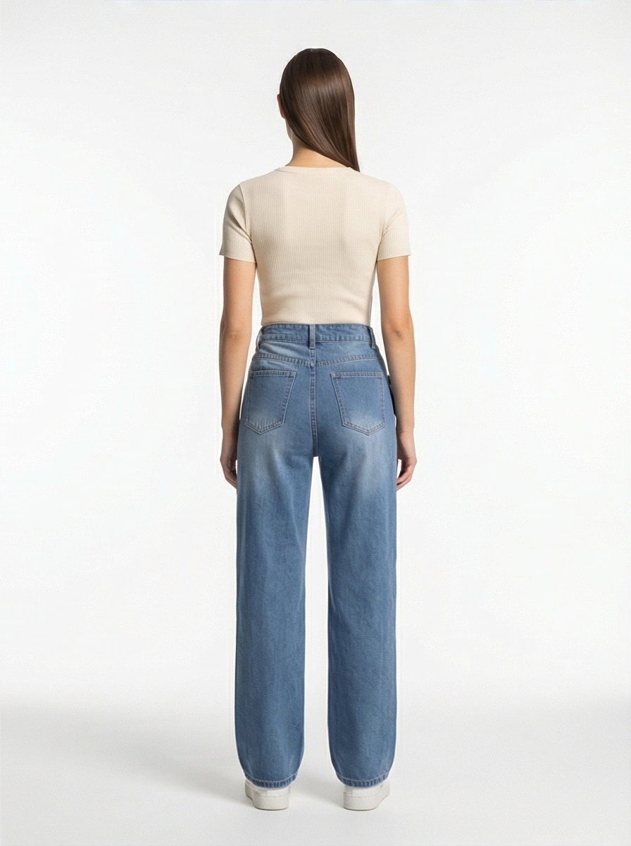 Person wearing blue jeans and a beige top on a white background