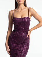 Woman wearing a purple sequin dress on a white background