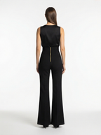 Black jumpsuit worn by a model on a white background