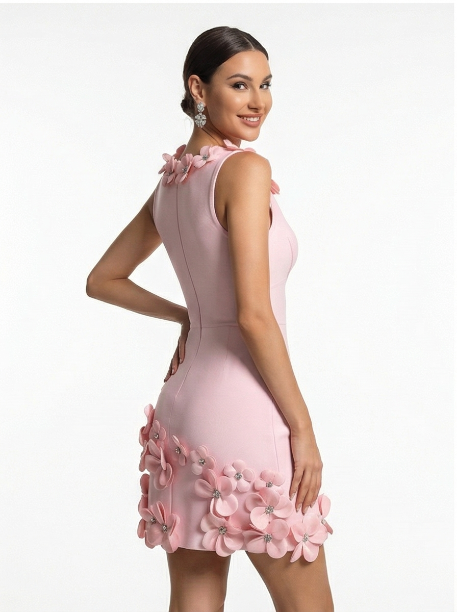 Woman wearing a pink dress with floral embellishments on a white background