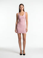 Woman wearing a pink sleeveless dress on a white background