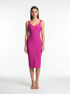 Woman wearing a bright pink sleeveless dress on a white background
