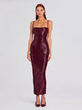 Woman wearing a burgundy sequin dress on a light gray background
