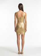 Gold dress worn by a model on a white background
