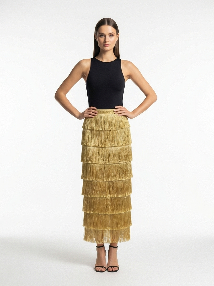 Woman wearing a black top and gold tiered skirt on a white background