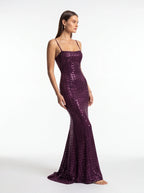 Woman wearing a purple sequin dress on a white background