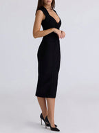 Black dress worn by a model on a light gray background