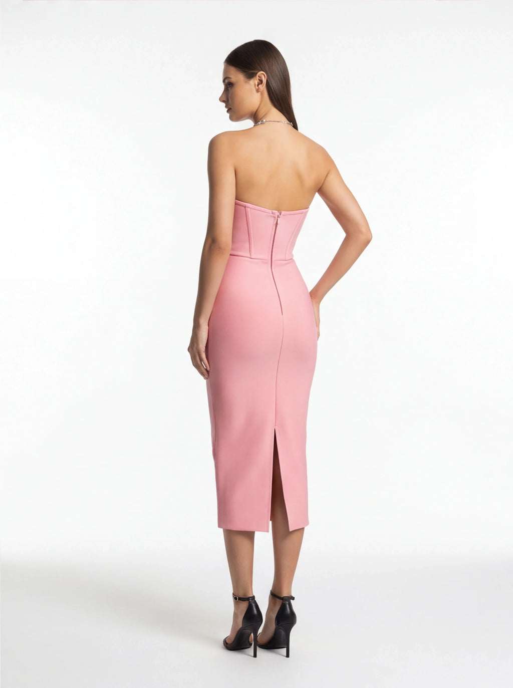 Woman wearing a pink strapless dress on a white background