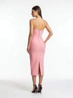 Woman wearing a pink strapless dress on a white background