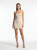 Woman wearing a beige strapless dress on a white background
