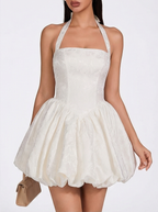 White halter neck dress worn by a model on a white background
