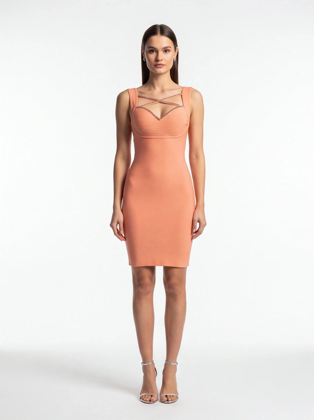 Woman wearing a peach dress with sheer mesh panels on a white background