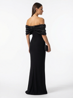 Woman wearing a black off-shoulder gown on a white background