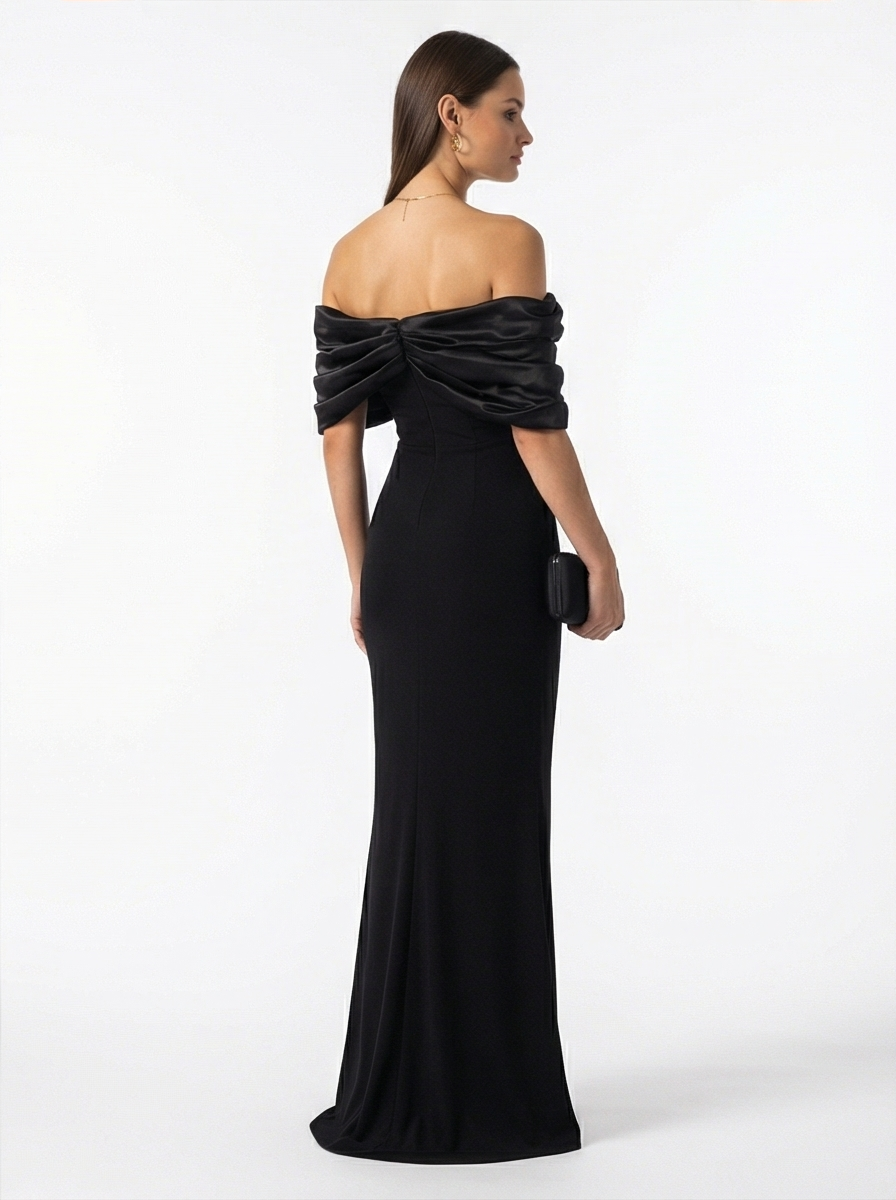 Woman wearing a black off-shoulder gown on a white background