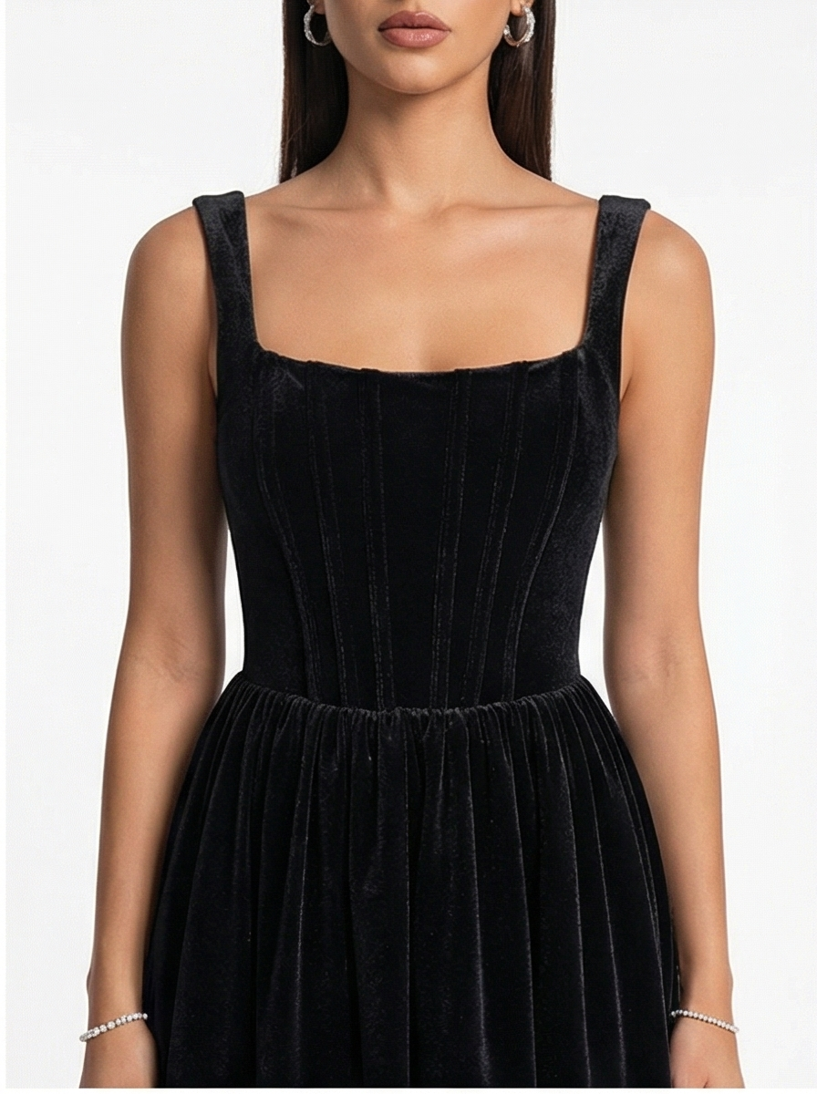 Black velvet dress worn by a model on a white background
