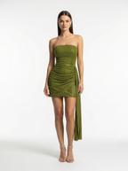 Woman wearing a green strapless dress with a slit on a white background