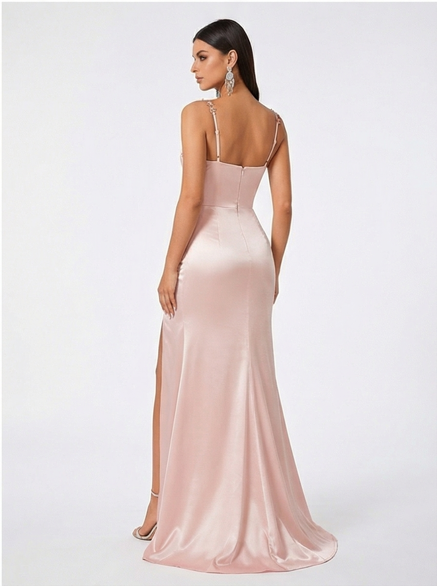 Woman wearing a pink evening gown with a slit on a white background