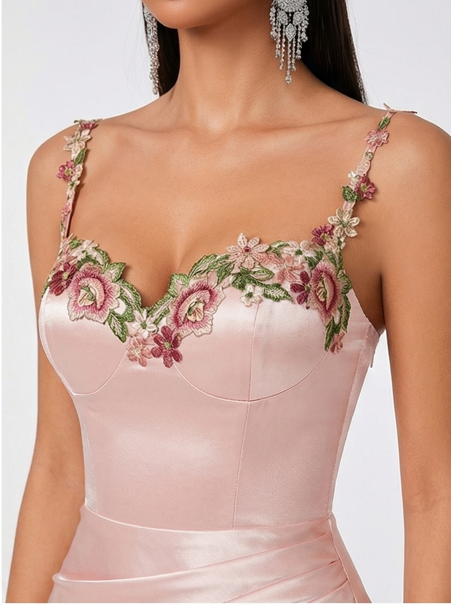 Pink dress with floral embroidery on a white background