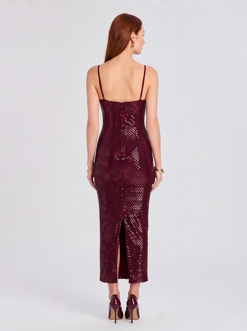 Woman wearing a burgundy sequin dress on a light gray background