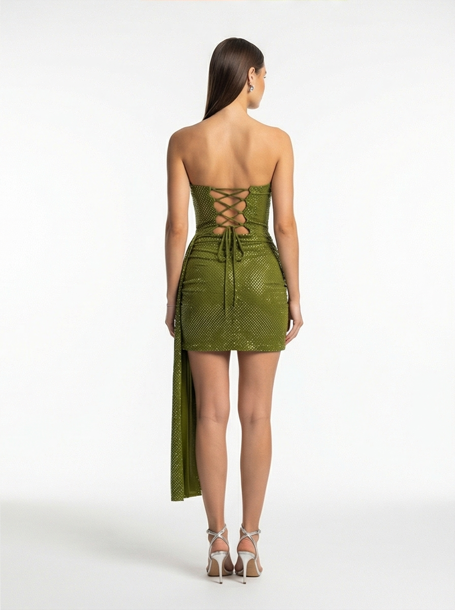 Woman wearing a green strapless dress with lace-up back on a white background