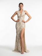 Woman wearing a beige evening gown with a high slit on a white background