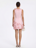 Pink dress with floral details worn by a model on a white background