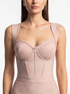 Woman wearing a pink compression garment on a plain background
