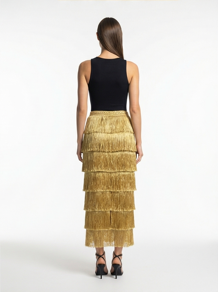 Woman wearing a black top and gold tiered skirt on a white background