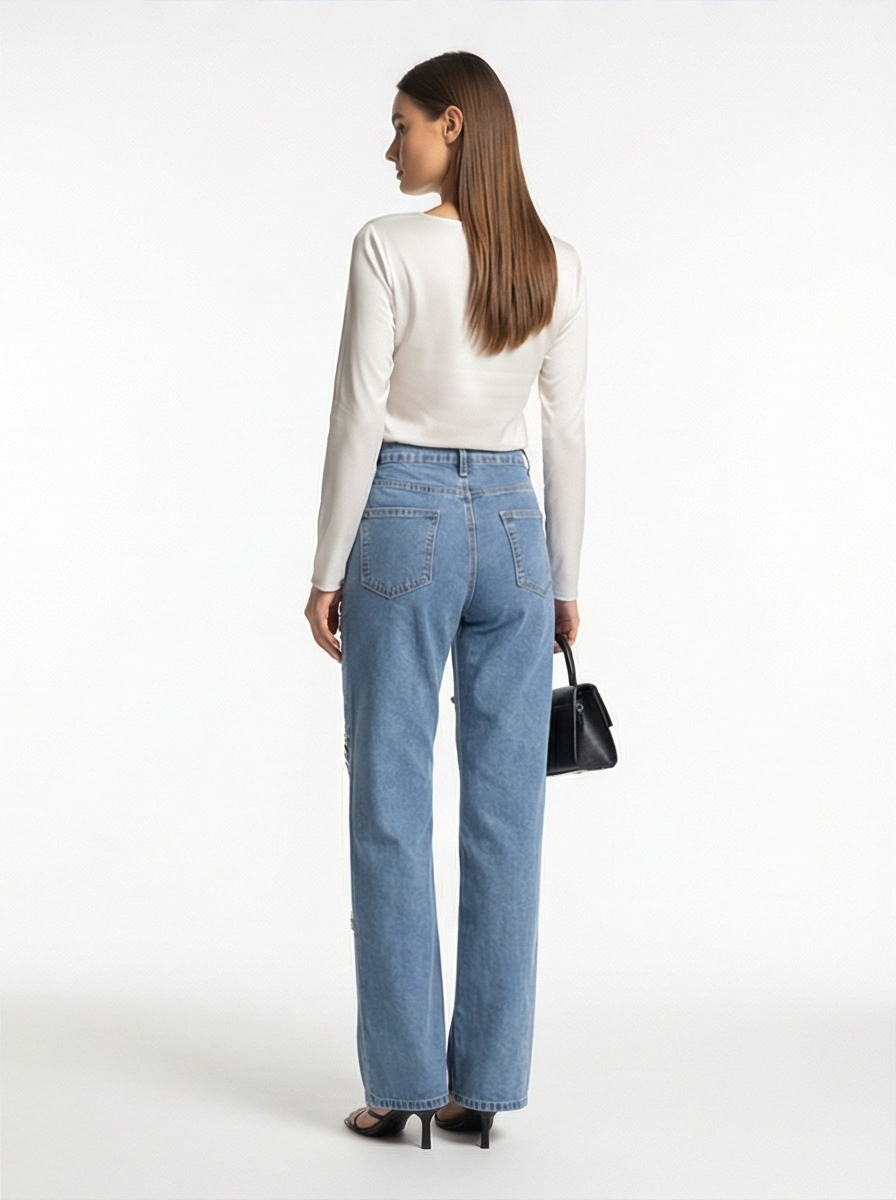 Woman wearing blue jeans and a white top on a white background