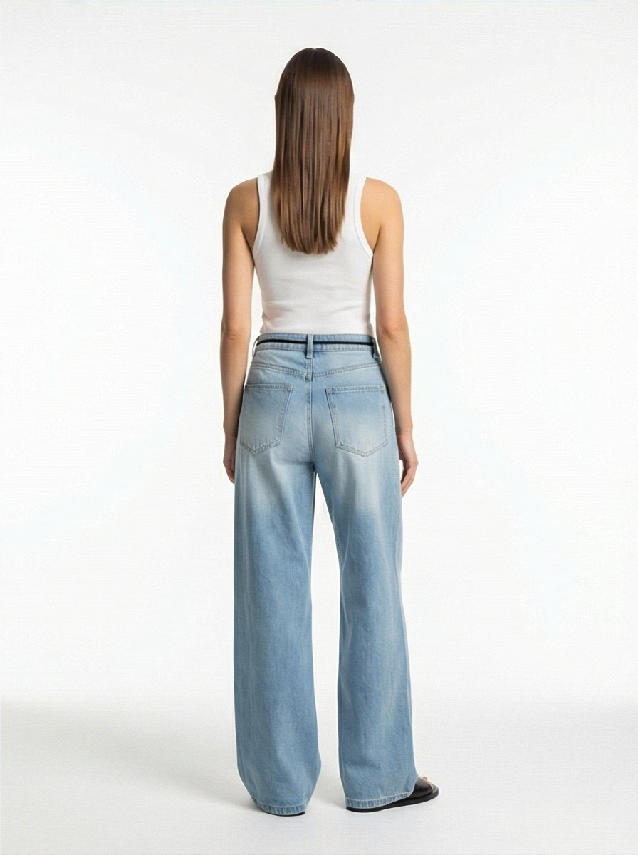 Woman wearing light blue jeans and a white tank top on a white background