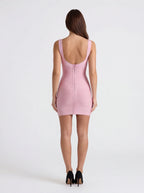 Woman wearing a pink dress with a white background