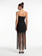 Black dress with sheer side panels worn by a model on a white background
