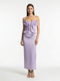 Woman wearing a strapless lavender gown with ruffled top on a white background