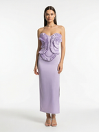 Woman wearing a strapless lavender gown with ruffled top on a white background