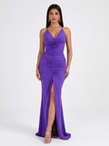 Woman wearing a purple evening gown with a high slit on a white background