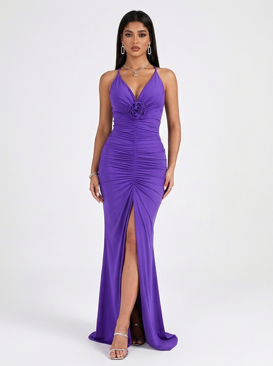 Woman wearing a purple evening gown with a high slit on a white background